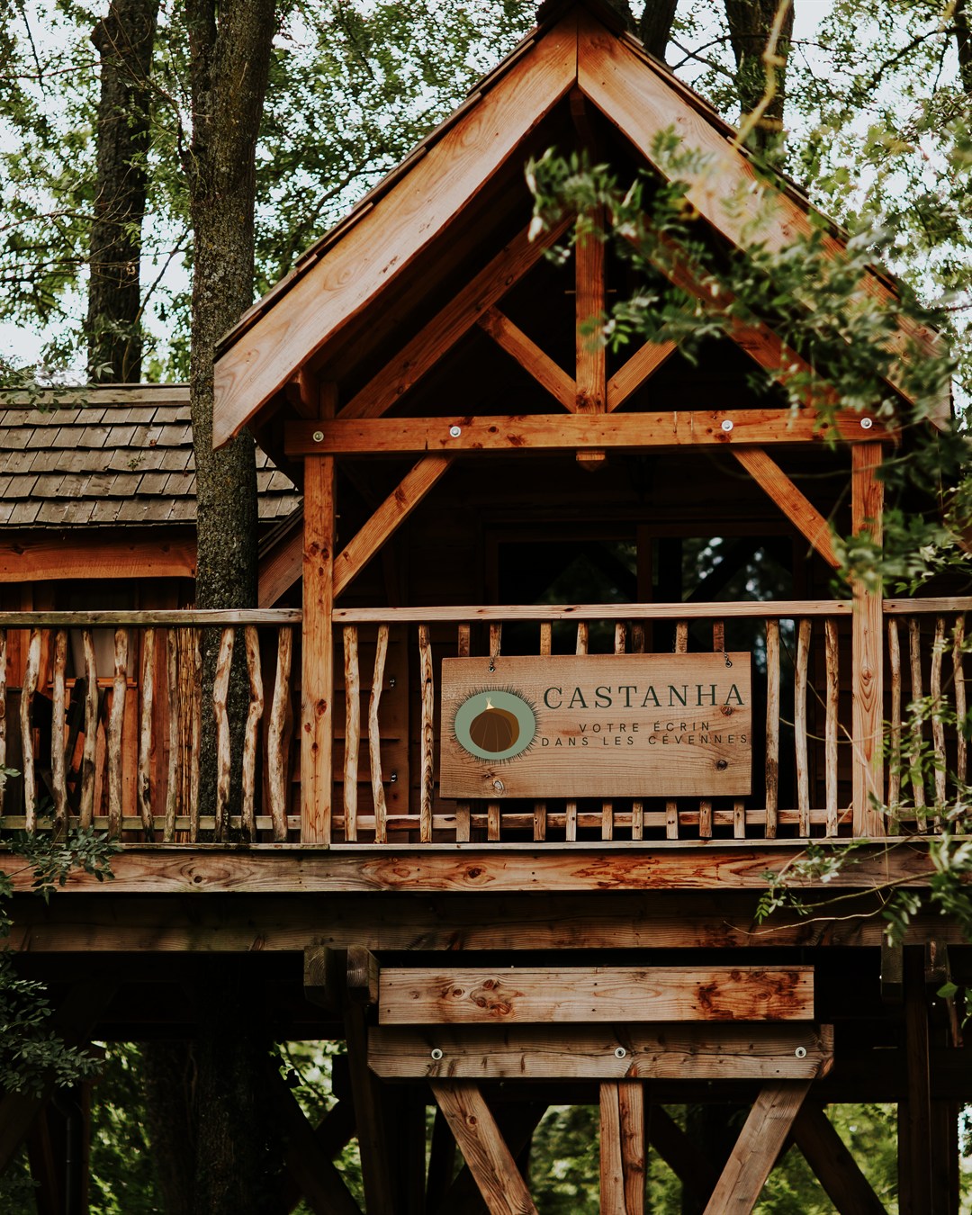 L'enseigne Castanha suspendue à la rambarde d'une cabane perchée dans les arbres